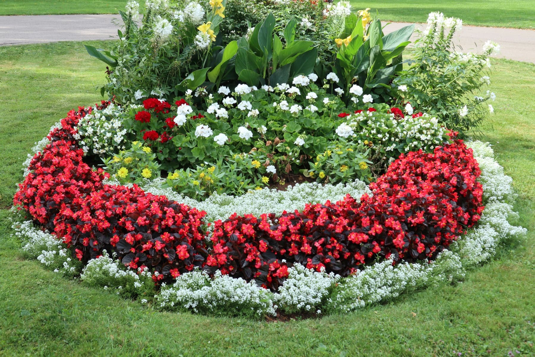 A colorful flower bed in a landscaped yard.